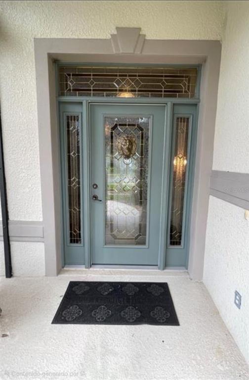 A light blue front door with decorative glass panels and a gold lion head knocker — 2915 SOUTHERN PINES LOOP, CLERMONT, FL