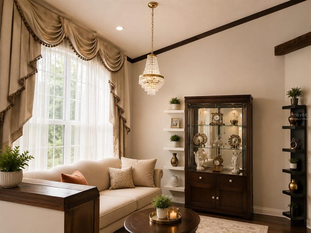 A living room features a crystal chandelier, a beige sofa, and a dark wood display cabinet — 2915 SOUTHERN PINES LOOP, CLERMONT, FL