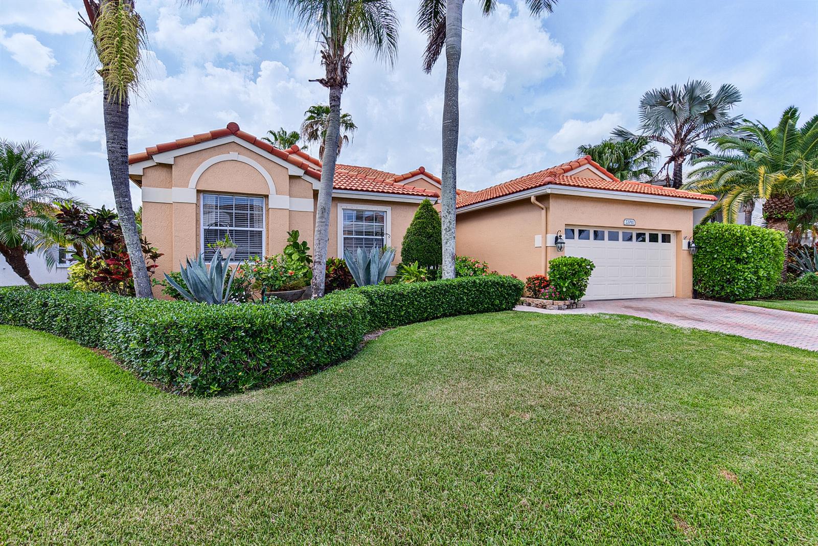 A single-story stucco house with a tile roof, a two-car garage, and manicured landscaping — 22011 Palm Grass Drive, Boca Raton FL 33428, BOCA RATON, FL