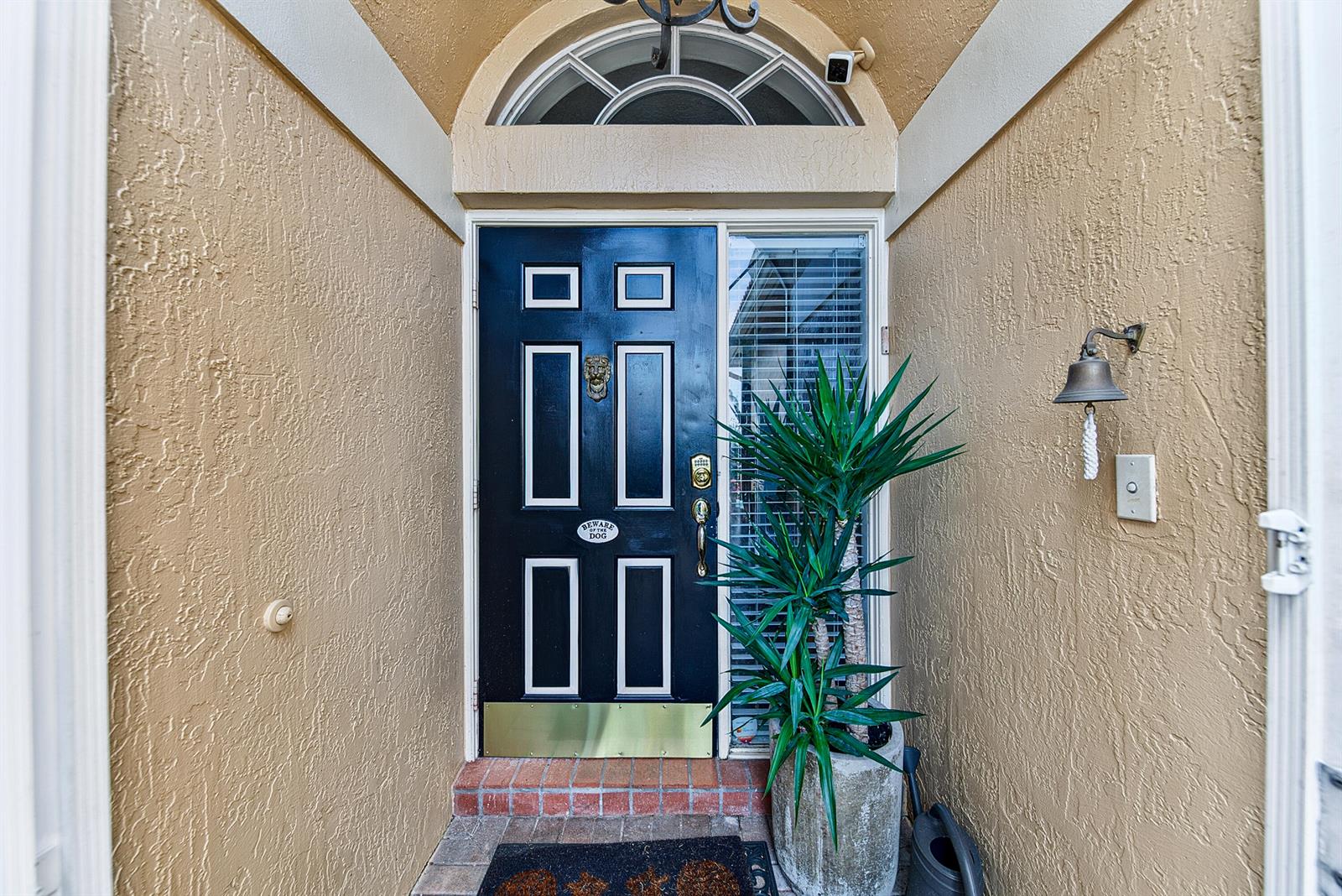 A black front door with a brass kickplate and lion knocker sits under an arched transom — 22011 Palm Grass Drive, Boca Raton FL 33428, BOCA RATON, FL
