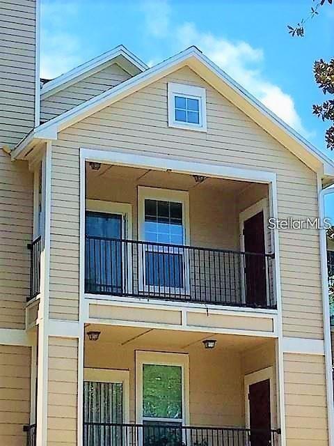 Exterior view of a two-story building with stacked balconies and tan horizontal siding — 2015 ERVING CIRCLE UNIT 304, OCOEE, FL