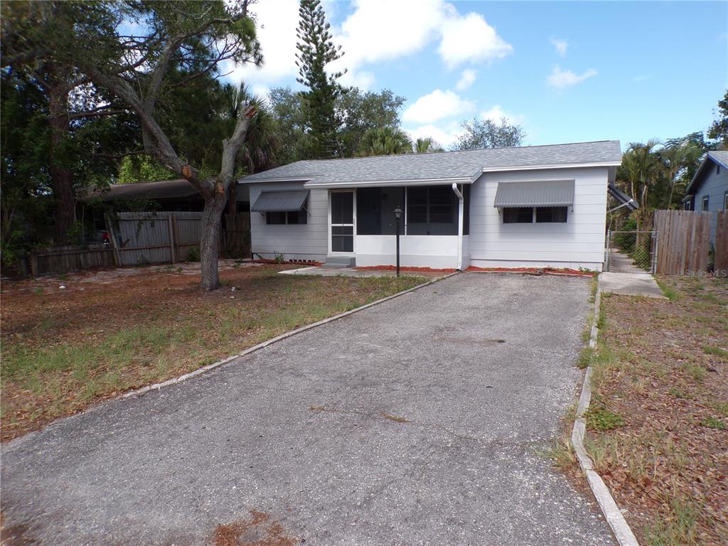 A single-story house with gray siding, a screened front porch, and a paved driveway — 4402 73RD STREET N, ST PETERSBURG, FL