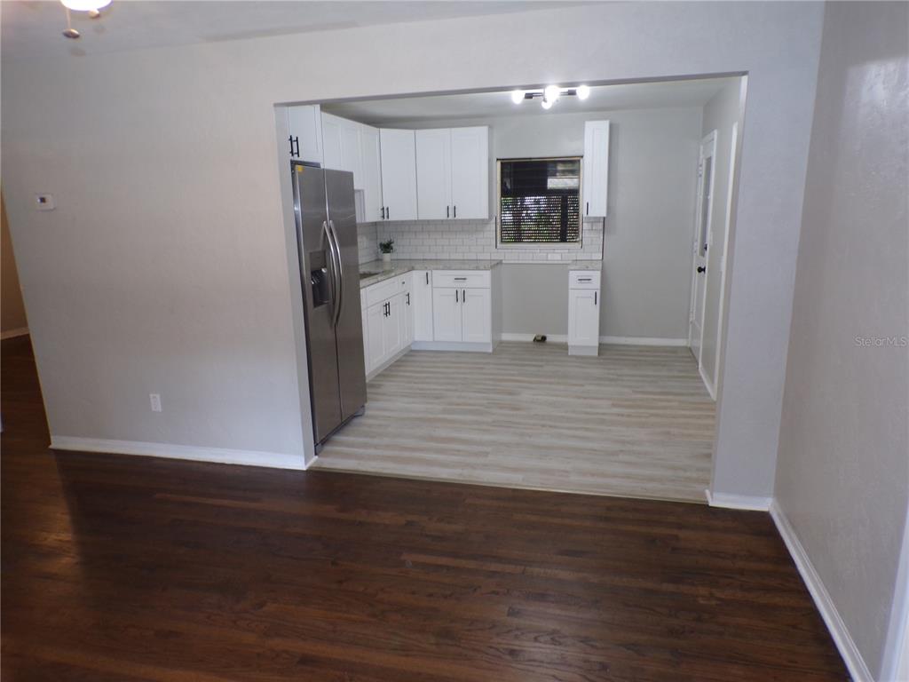 A kitchen with white cabinets, stainless steel appliances, and light wood-look flooring — 4402 73RD STREET N, ST PETERSBURG, FL