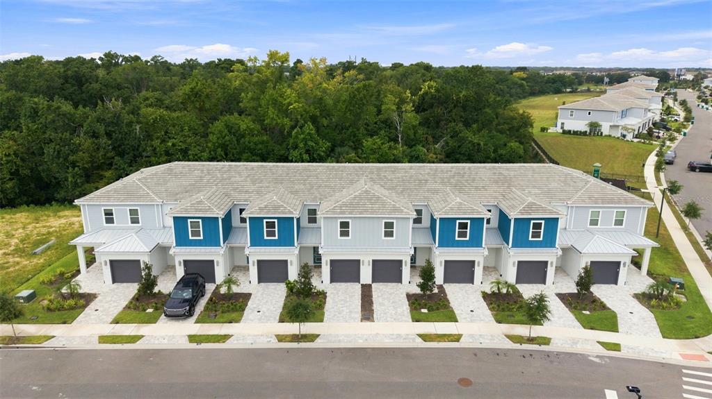 An aerial view of a multi-unit townhouse building with gray roofs and blue accents — 1216 ROYAL VIEW TERRACE, KISSIMMEE, FL