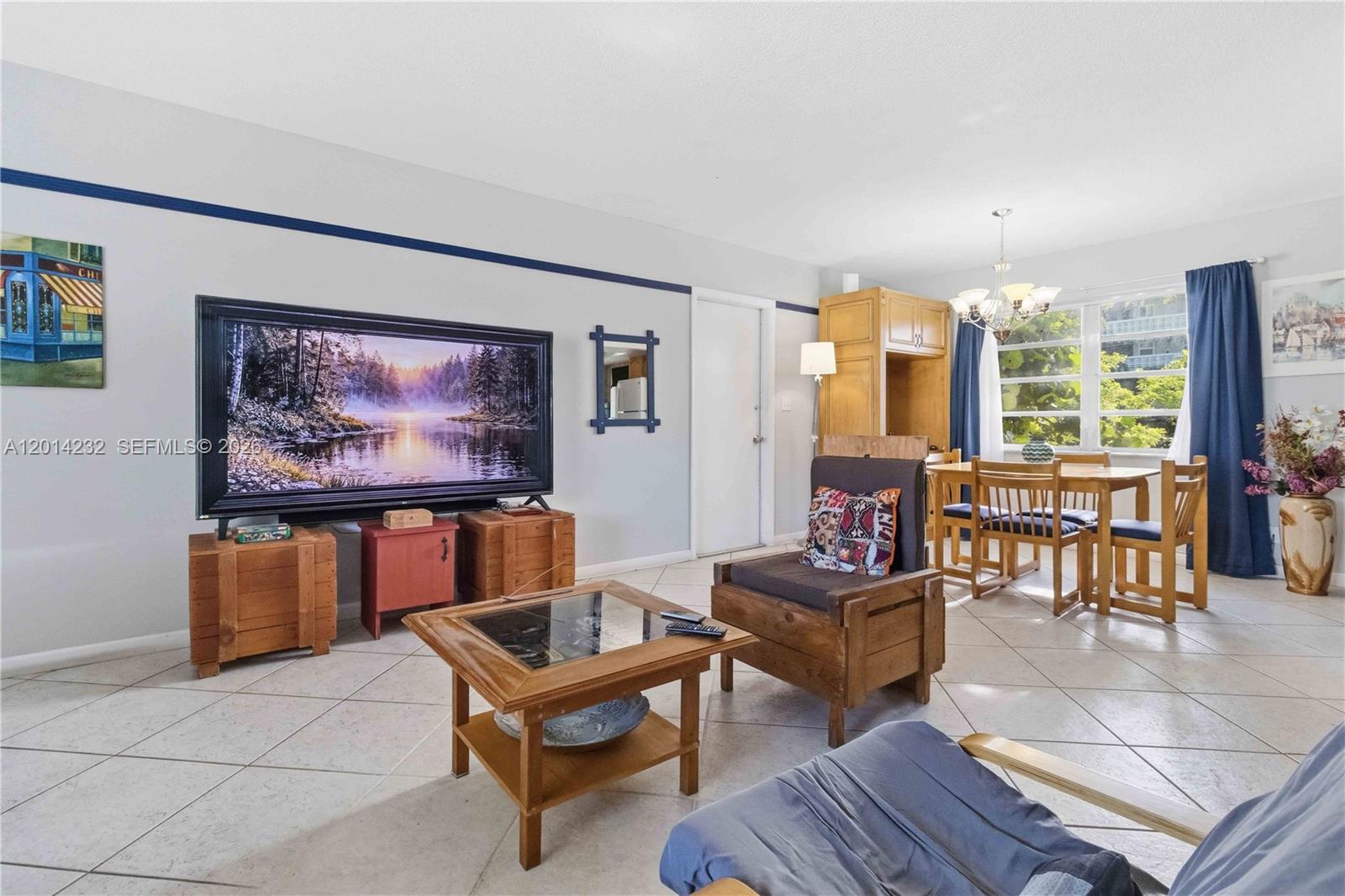A living and dining area features tile floors, a large television, and wooden furniture — 1501 Arthur St # 6, Hollywood FL 33020, HOLLYWOOD, FL