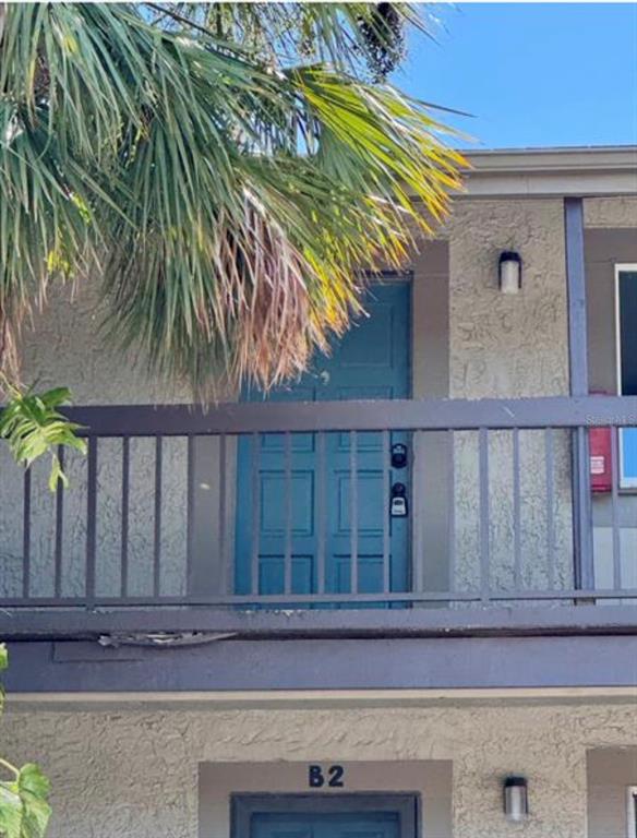 A blue door with two smart locks is located on the second-floor balcony — 6312 NEWTOWN CIRCLE UNIT 12C2, TAMPA, FL