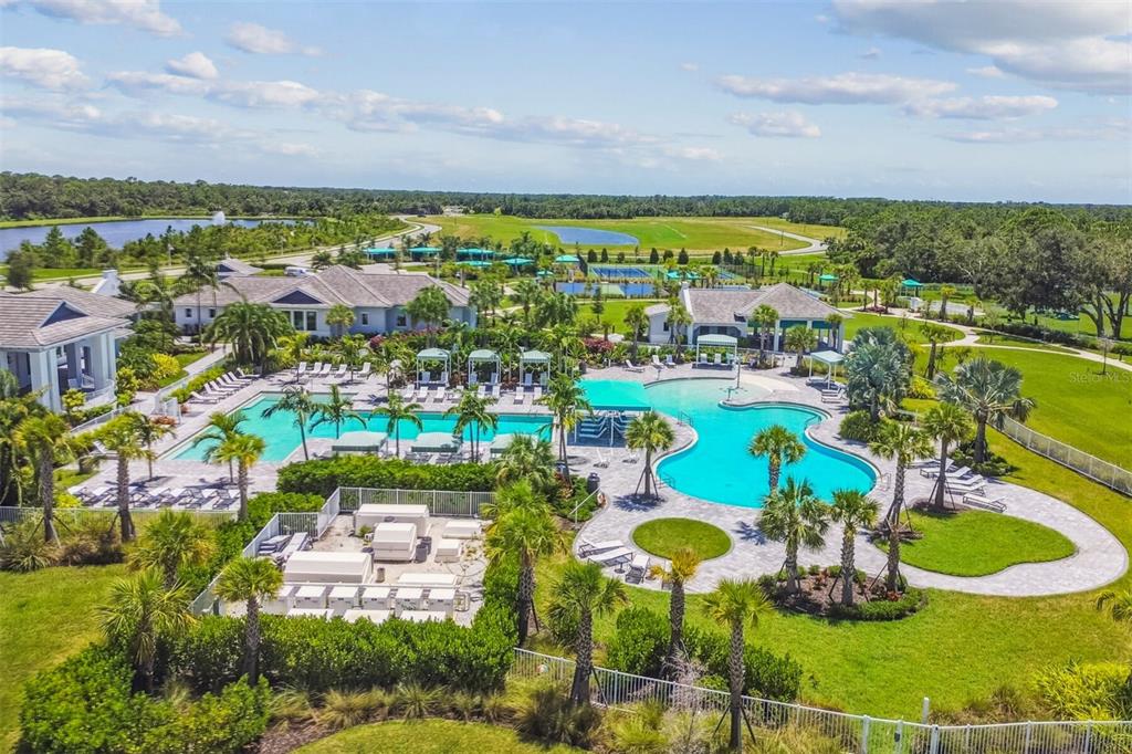 A grassy foreground leads to a dense area of trees and palm plants under a sky — 9718 CRYSTAL ISLES CIRCLE, SARASOTA, FL