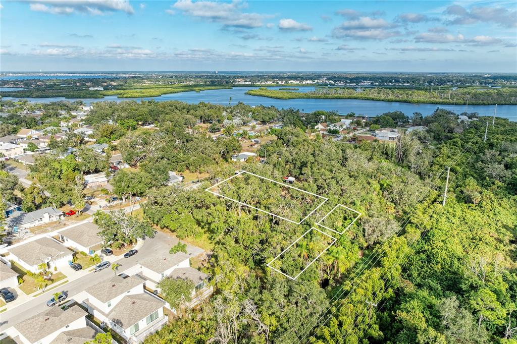 An aerial view shows three outlined vacant lots surrounded by trees near a residential neighborhood — 3006 12TH AVENUE E, BRADENTON, FL
