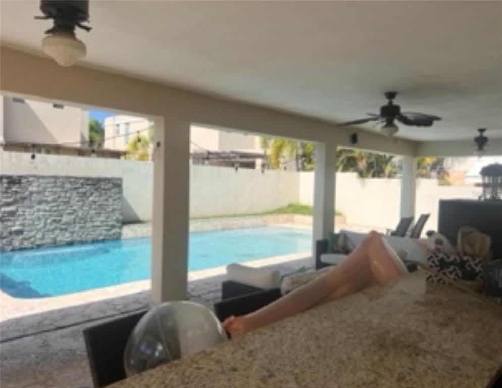 A covered patio with a granite bar overlooks a swimming pool and stone accent wall — Mar Caspio M-6 PASEO LOS CORALES 2, DORADO, PR