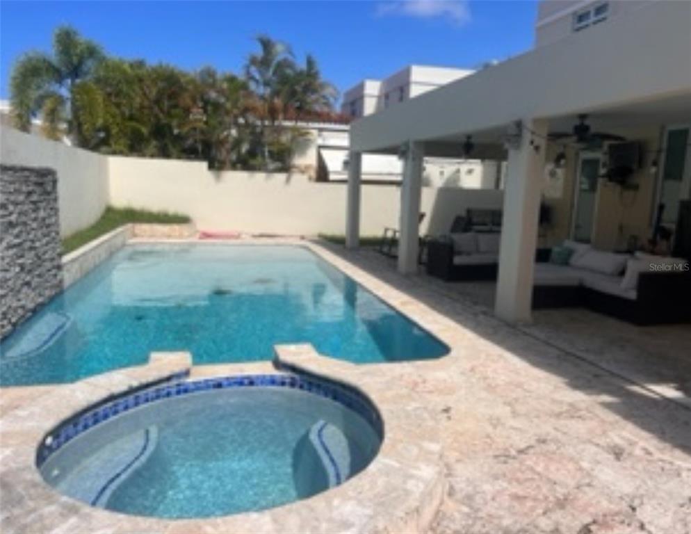 A backyard features a swimming pool, a circular spa, and a covered patio with furniture — Mar Caspio M-6 PASEO LOS CORALES 2, DORADO, PR