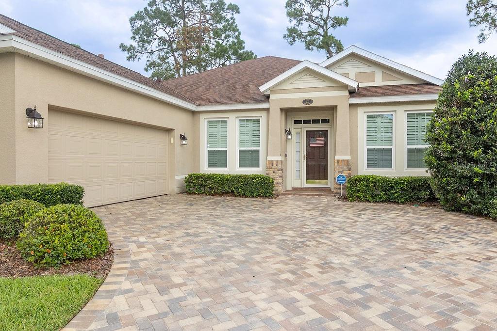 A single-story house with a beige stucco exterior, a paved driveway, and a front entrance — 107 CURRY RISE COURT, DELAND, FL