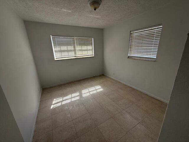 An empty bedroom features white walls, tile flooring, and two windows with closed blinds — 635 NW 5th Street, Boynton Beach FL 33435, BOYNTON BEACH, FL