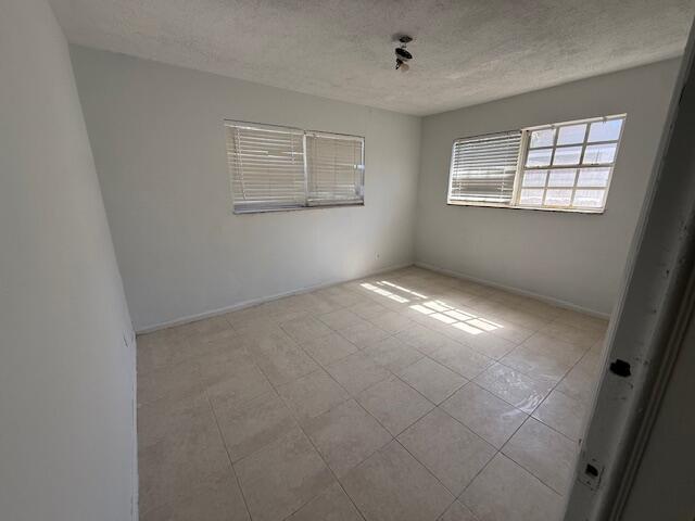 An empty bedroom with white walls, tile flooring, and two windows with blinds — 635 NW 5th Street, Boynton Beach FL 33435, BOYNTON BEACH, FL