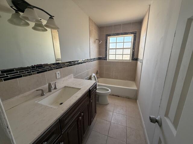 A bathroom features a dark wood vanity, a beige countertop, and a tiled tub-shower combo — 635 NW 5th Street, Boynton Beach FL 33435, BOYNTON BEACH, FL