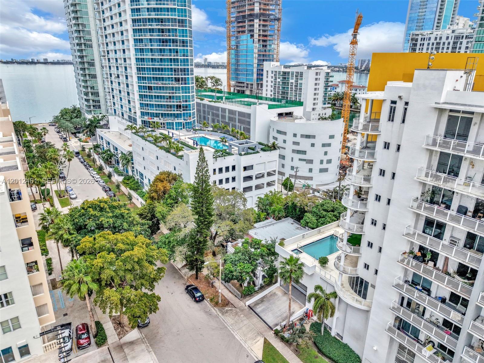 An aerial view shows high-rise apartment buildings, a street with parked cars, and swimming pools — 452 NE 30th St, Miami FL 33137, MIAMI, FL