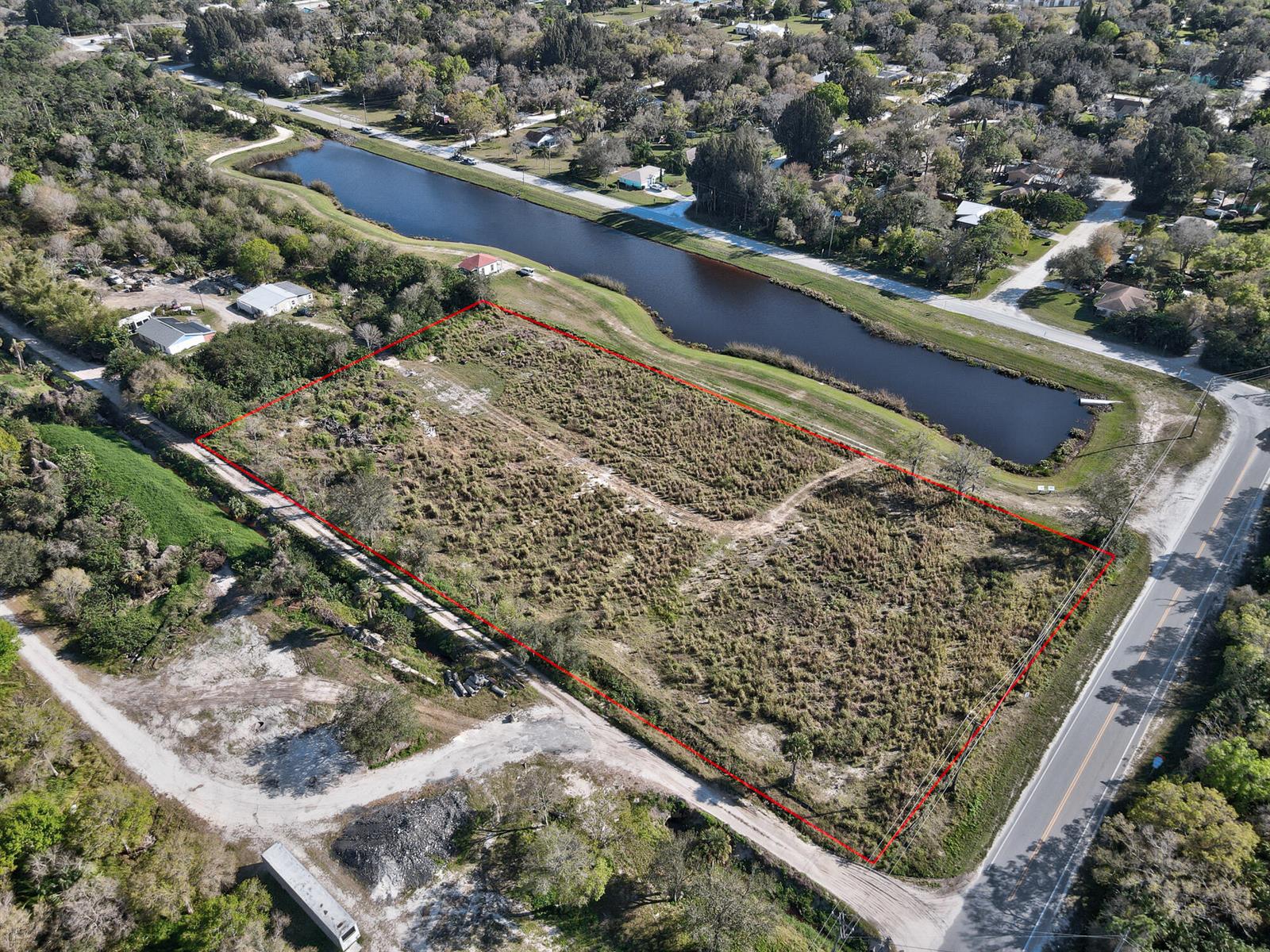 An aerial view shows a vacant, rectangular lot outlined in red next to a canal — 13765 99th Street, Fellsmere FL 32948, FELLSMERE, FL