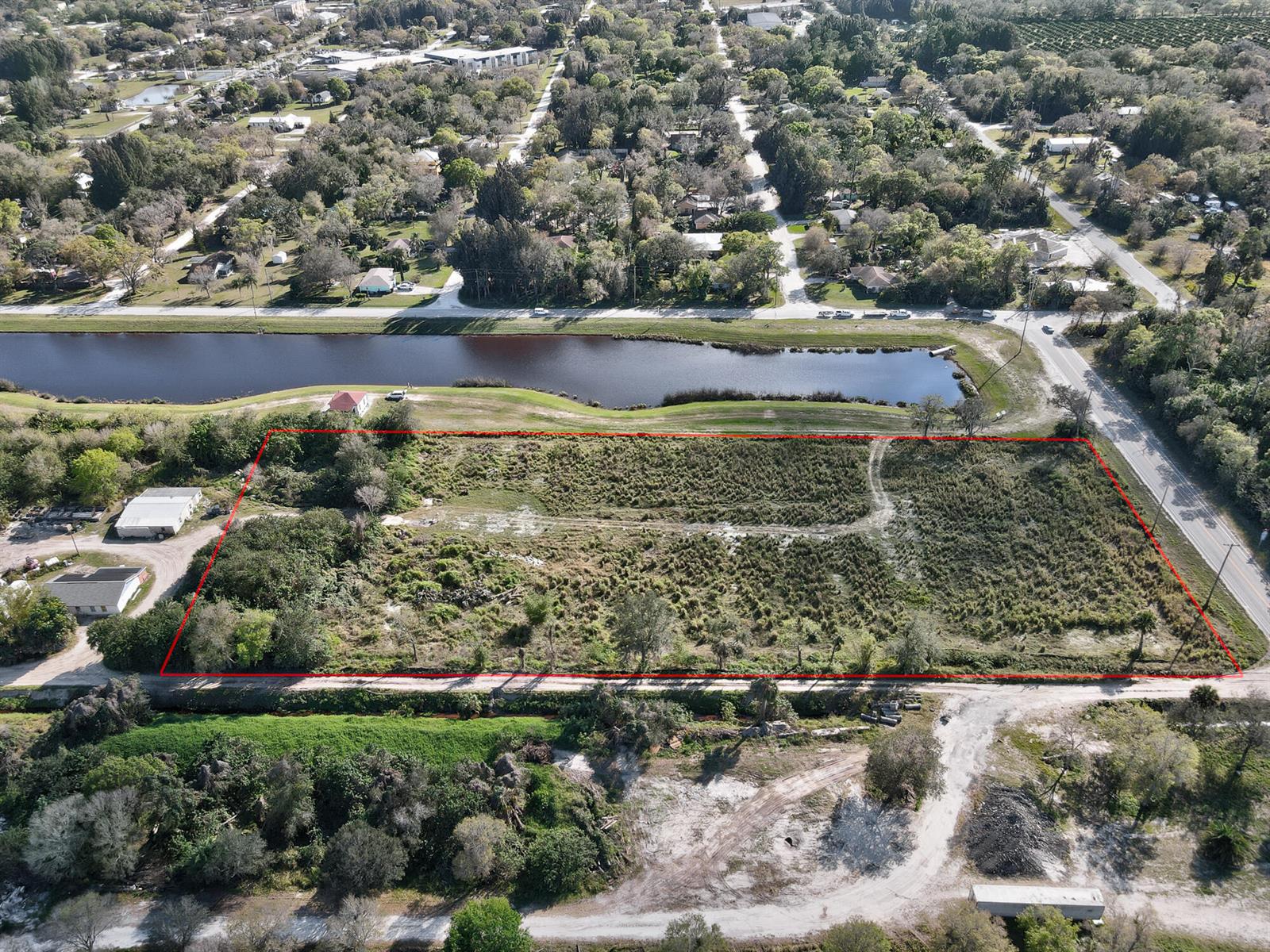 An aerial view shows a rectangular vacant lot outlined in red next to a canal — 13765 99th Street, Fellsmere FL 32948, FELLSMERE, FL