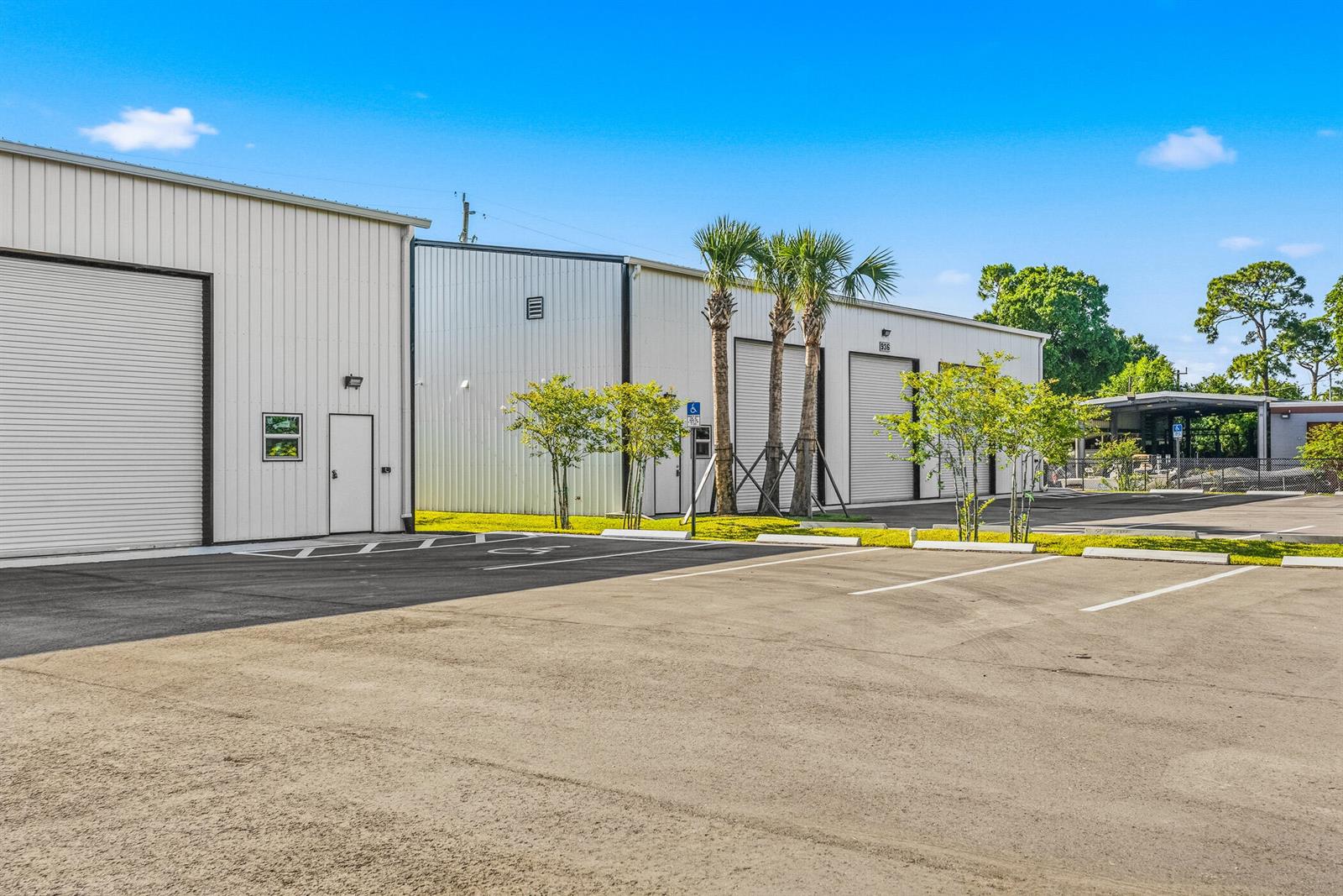 A commercial warehouse building with roll-up doors and a paved parking lot — VERO BEACH, FL