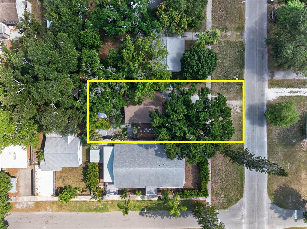 An aerial view shows a house surrounded by dense trees within a yellow rectangular border — 1213 55TH STREET S, GULFPORT, FL