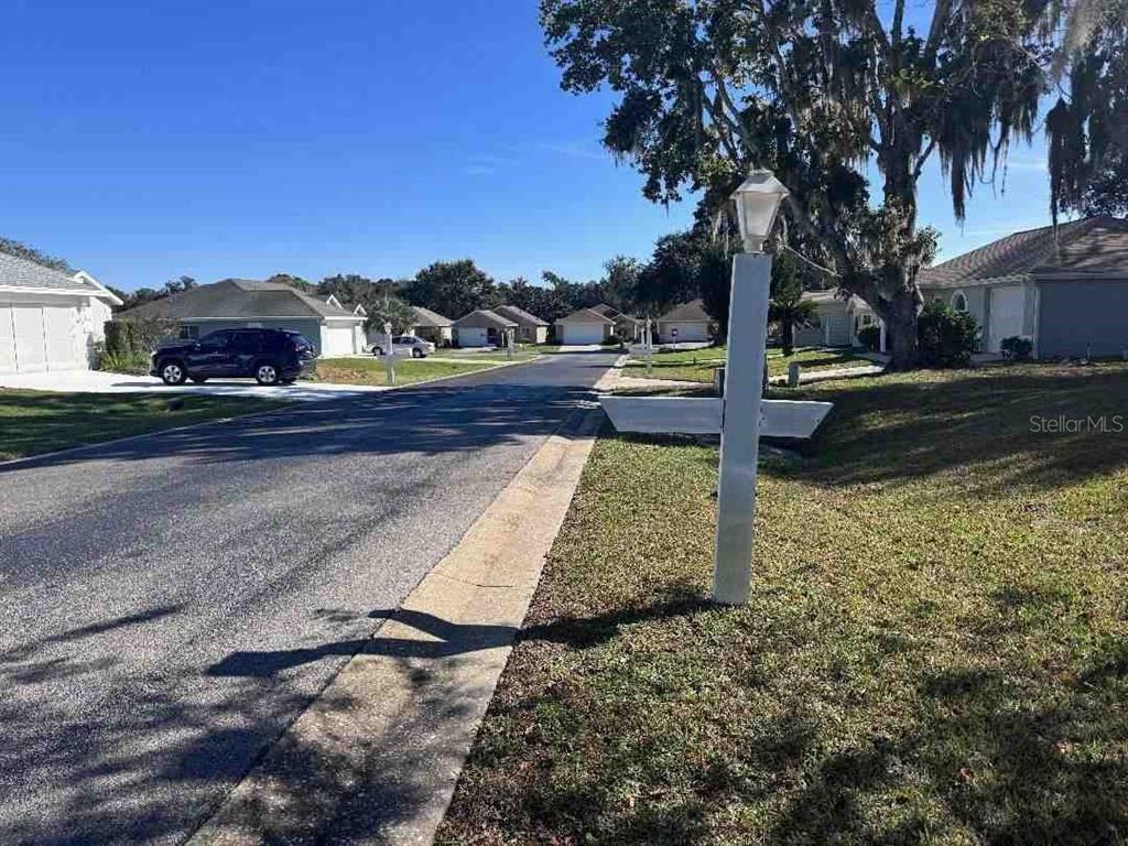A residential street view features a white signpost in the foreground and several suburban houses — 5110 NW 19TH PLACE, OCALA, FL