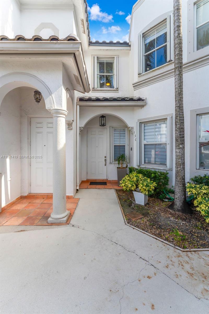The exterior view shows two white front doors with arched entryways and tiled porches — 5610 NW 107th Ave # 1306, Doral FL 33178, DORAL, FL