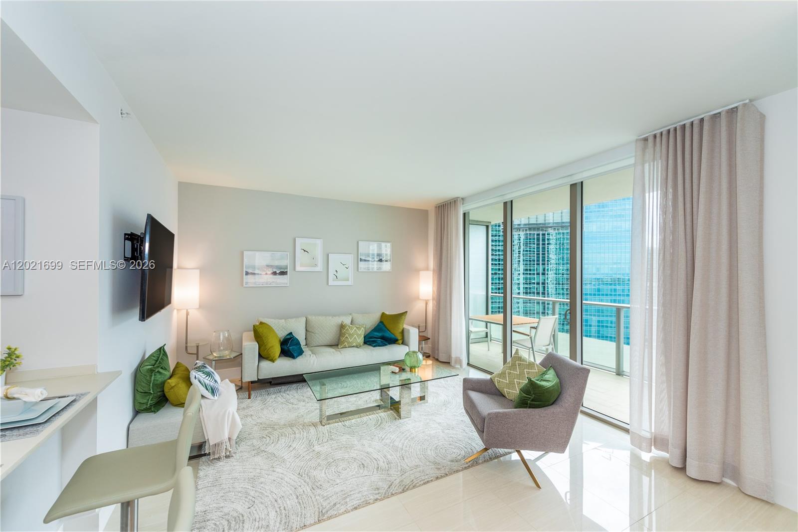 A modern living room features a sofa, armchair, glass coffee table, and floor-to-ceiling windows — 1300 Brickell Bay Dr # 2900, Miami FL 33131, MIAMI, FL
