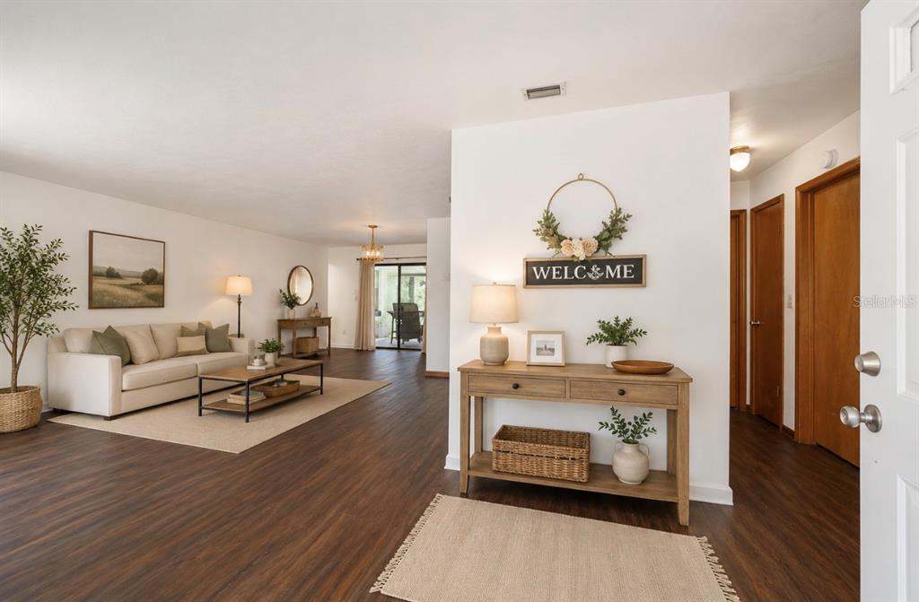 A bright entryway leads into a living room with wood-look flooring and neutral decor — 23063 SW EDGEWATER BOULEVARD, DUNNELLON, FL