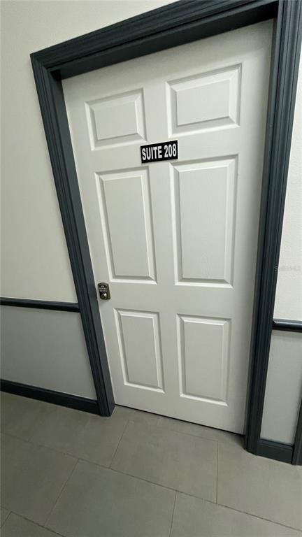 A white six-panel door labeled Suite 208 features a digital keypad lock and dark trim — 722 PATRICK STREET UNIT 208, KISSIMMEE, FL