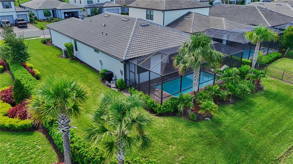 An aerial view of a suburban house with a screened-in pool and palm trees — 818 PINTAIL COVE, BRADENTON, FL