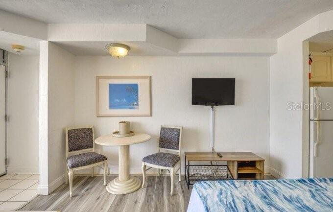 A small dining area with a round table, two chairs, and a wall-mounted television — 2700 N ATLANTIC AVENUE UNIT 421, DAYTONA BEACH, FL