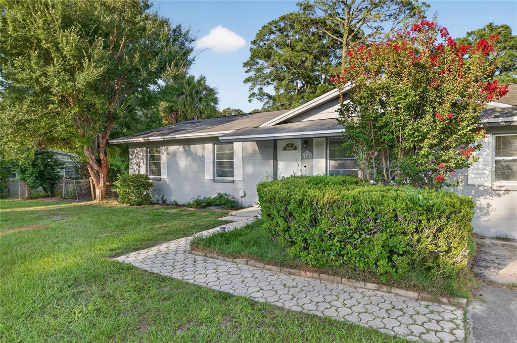 A single-story gray house with a stone walkway and a large blooming crape myrtle tree — 17409 NW 240TH TERRACE, HIGH SPRINGS, FL