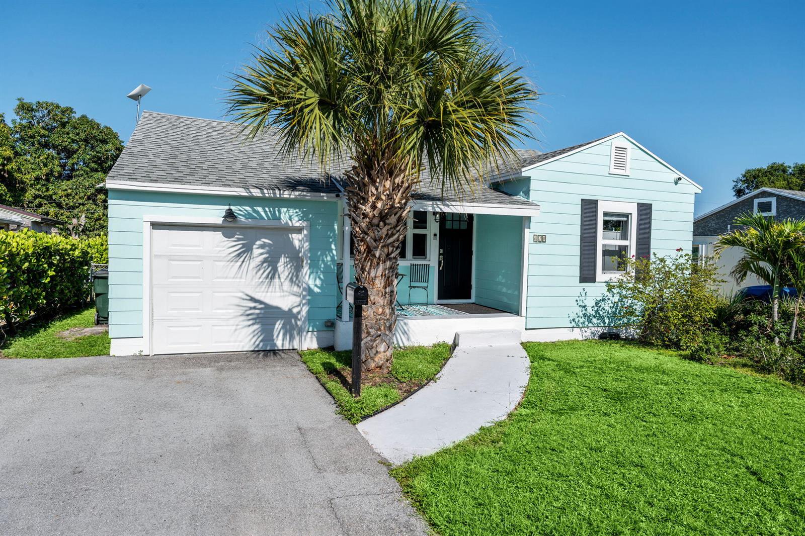 A light blue single-story house features a white garage door, a palm tree, and landscaping — 620 N B Street, FL 33460, FL