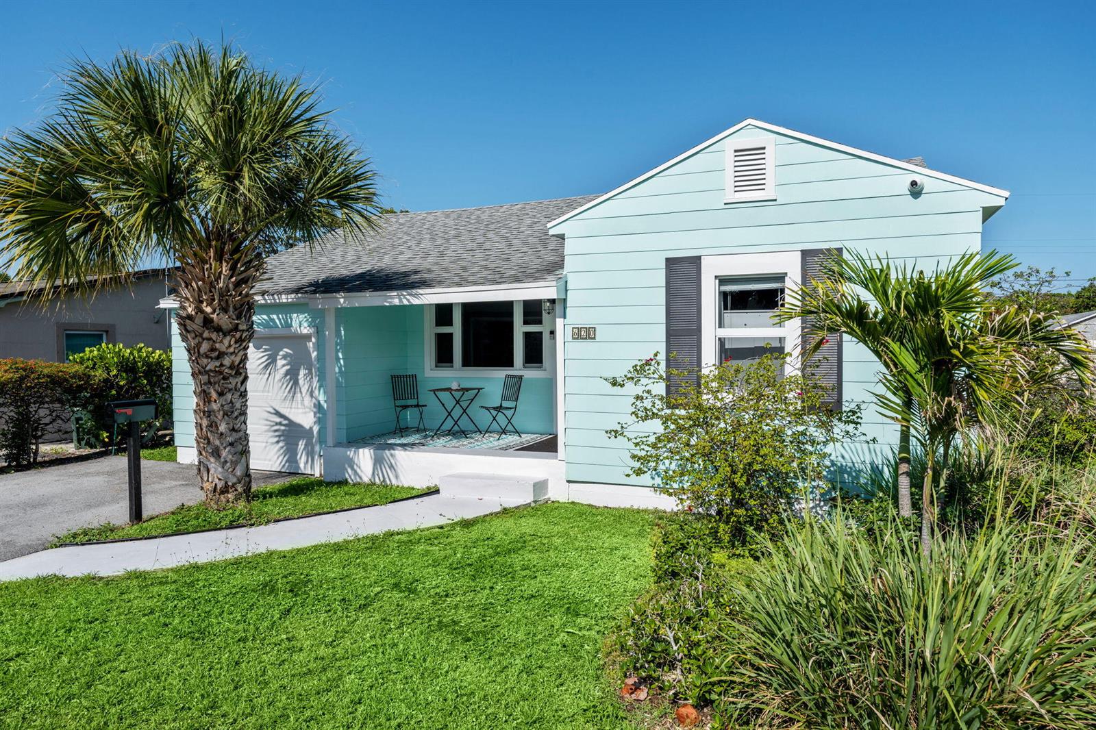 A light blue, single-story house with a front porch, palm tree, and green lawn — 620 N B Street, FL 33460, FL