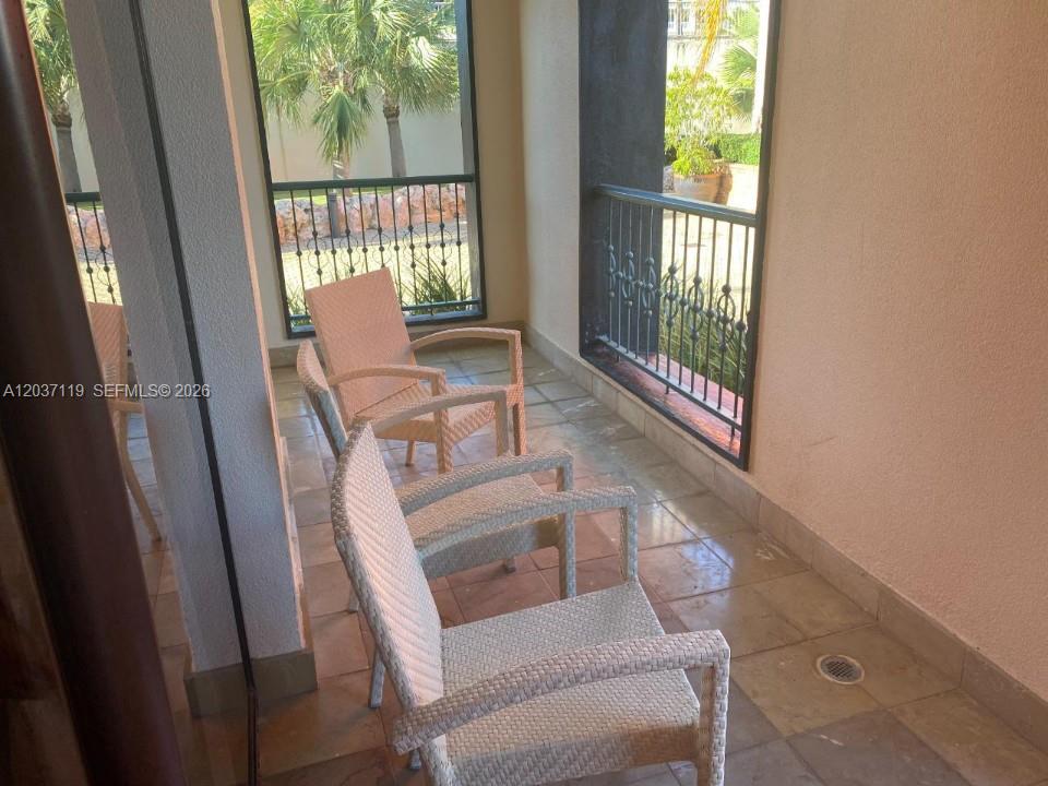 A covered balcony features tiled flooring, three wicker chairs, and black metal railings — 0 Fishing lodge # 0, FL, FL