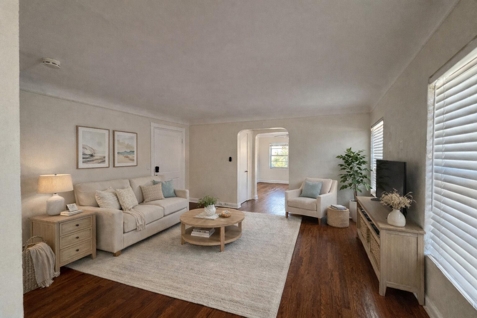 A bright living room features a beige sofa, round coffee table, and hardwood floors — 14 S M Street # 3, FL 33460, FL