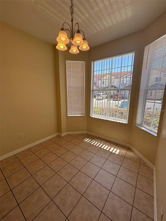 A dining area with tile flooring, a chandelier, and windows with blinds — 1237 S BEACH CIRCLE, KISSIMMEE, FL