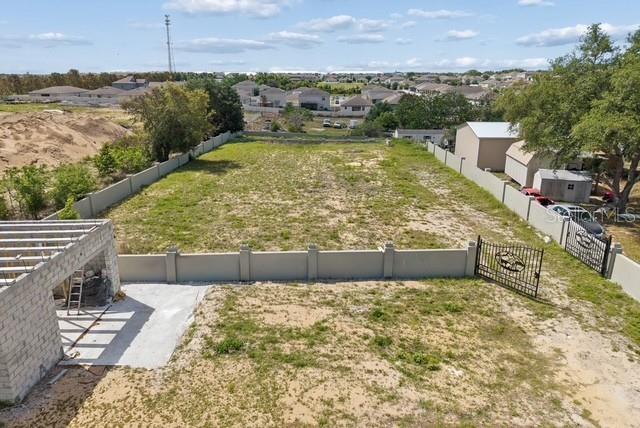 An aerial view shows a fenced, vacant rectangular lot with a partially constructed concrete structure — 1501 NORTH BOULEVARD W, DAVENPORT, FL