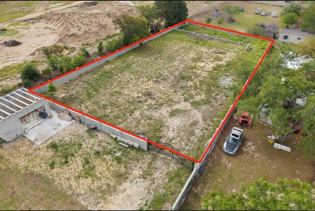 An aerial view shows a fenced, rectangular vacant lot with a small concrete structure nearby — 1501 NORTH BOULEVARD W, DAVENPORT, FL