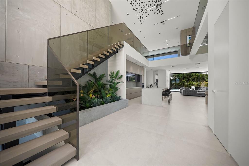 A modern, open-concept living space features a floating staircase, indoor garden, and high ceilings — 1640 WALDEMERE STREET, SARASOTA, FL
