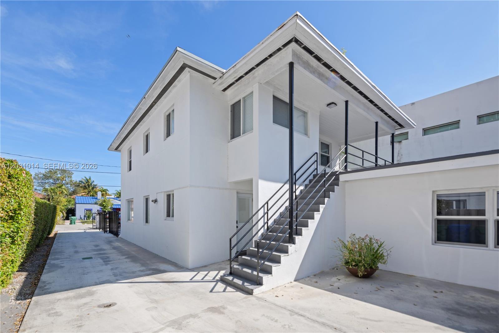 The exterior of a two-story white building features an outdoor staircase leading to a balcony — 2240 SW 16th Ct # U, Miami FL 33145, MIAMI, FL