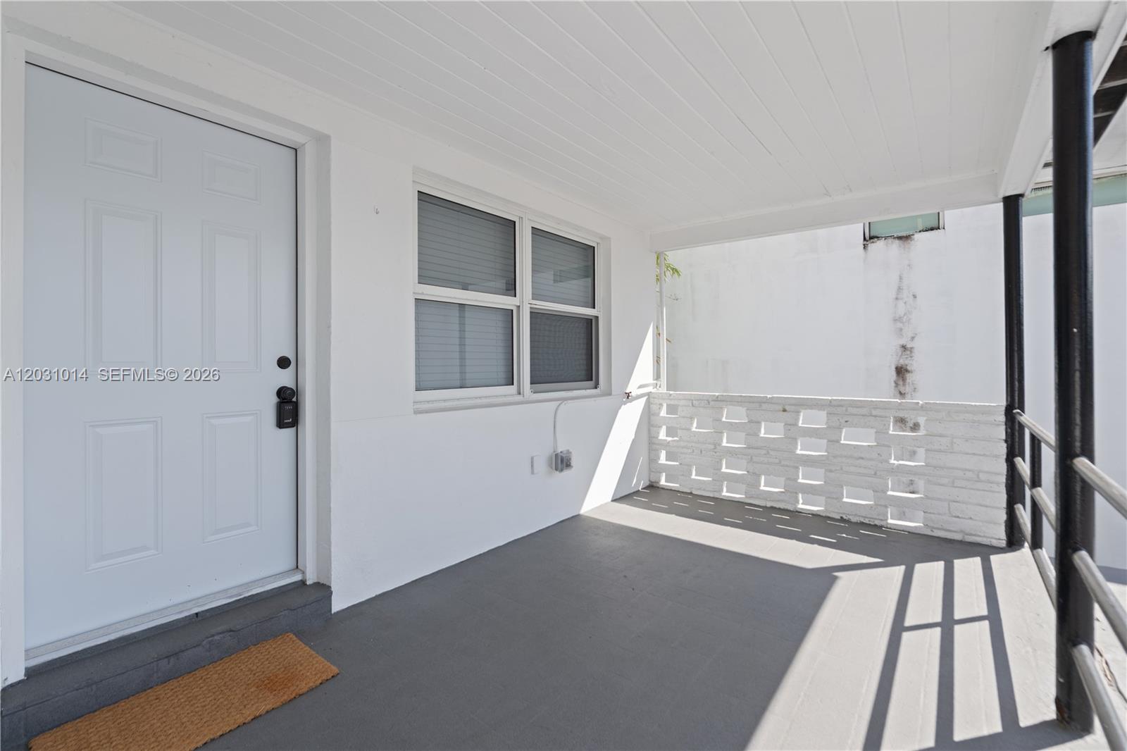 A covered porch features a white door, a window, and a white brick privacy wall — 2240 SW 16th Ct # U, Miami FL 33145, MIAMI, FL