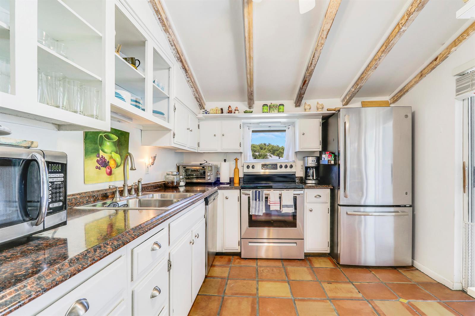 A kitchen with white cabinets, stainless steel appliances, granite countertops, and exposed wooden ceiling beams — 1329 Chippewa Street, Jupiter FL 33458, JUPITER, FL