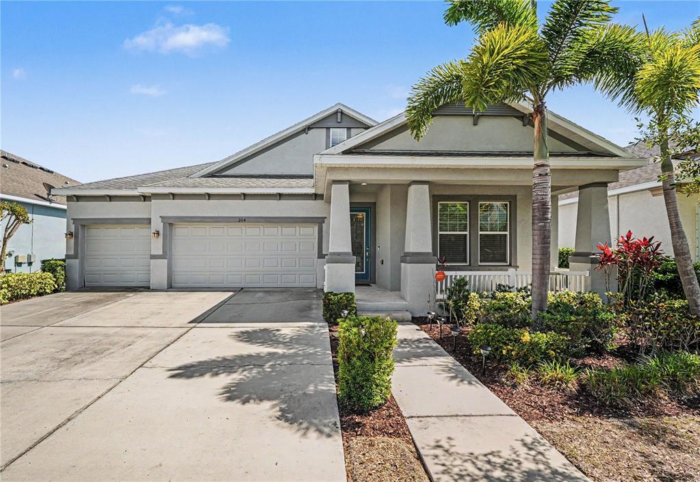 A single-story house with a two-car garage, a front porch, and a concrete driveway — 204 SHELL CREEK COURT, APOLLO BEACH, FL