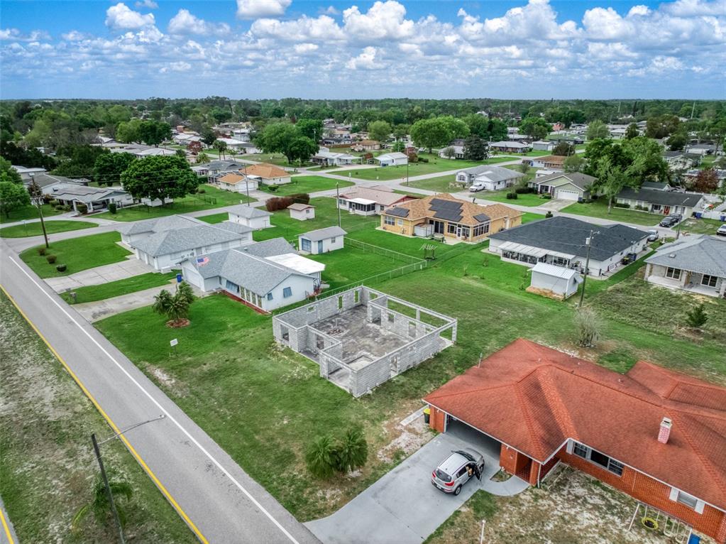 An aerial view shows a residential neighborhood with a concrete block house under construction — 229 WHATLEY BOULEVARD, SEBRING, FL