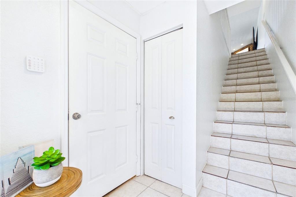 An entryway features a white door, a bi-fold closet, and tiled stairs leading upward — 637 PINELLAS BAYWAY S UNIT 301, TIERRA VERDE, FL