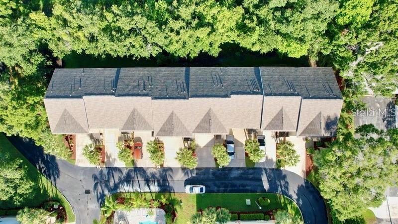 An aerial view shows a multi-unit townhouse building with a dark shingled roof and garages — 14 SEAGRAPE CIRCLE, CLEARWATER, FL