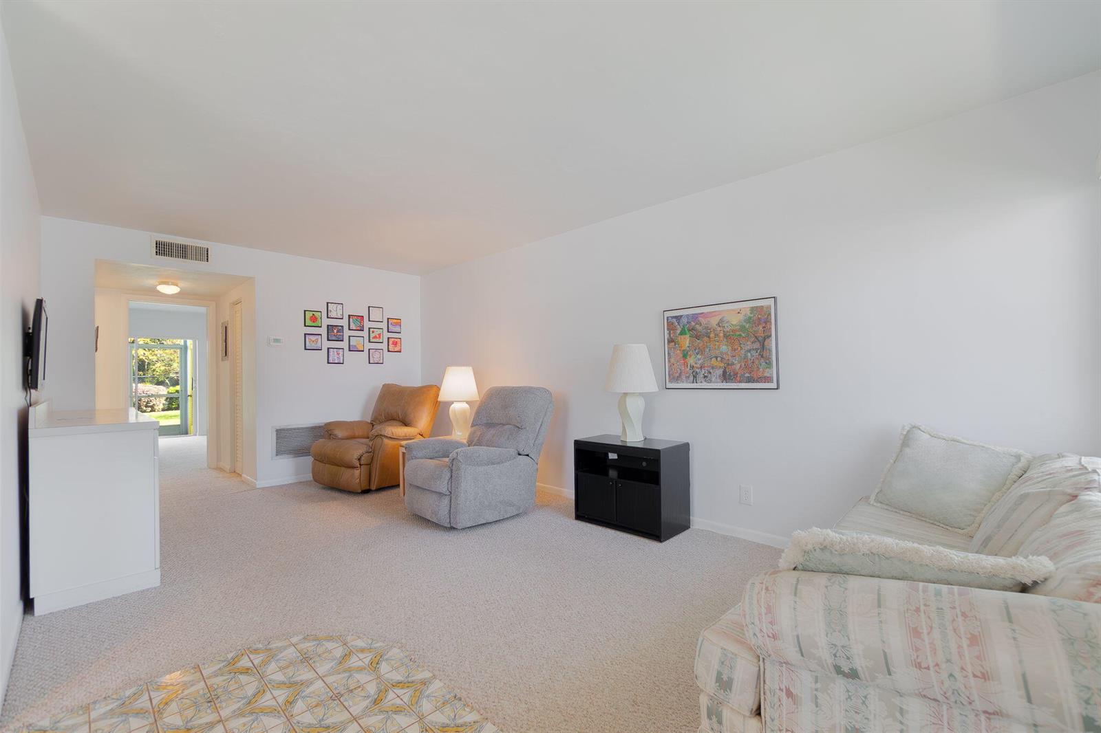 A living room features carpeted floors, two recliners, a sofa, and a framed wall print — 2840 Cynthia Lane # 101, FL 33461, FL