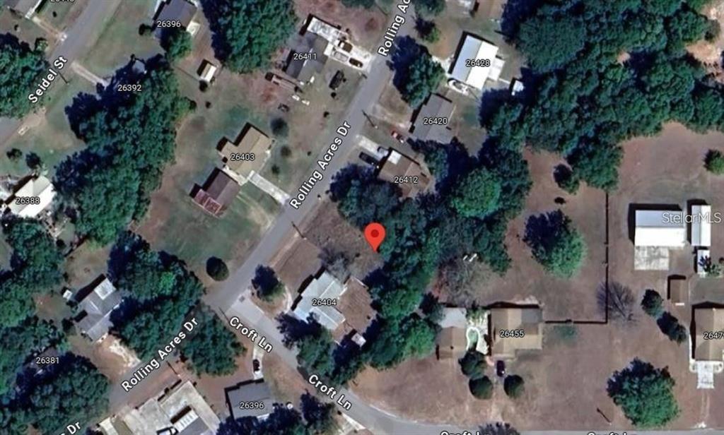 This is an aerial map view of a residential lot marked with a red pin — 26408 ROLLING ACRES DRIVE, BROOKSVILLE, FL