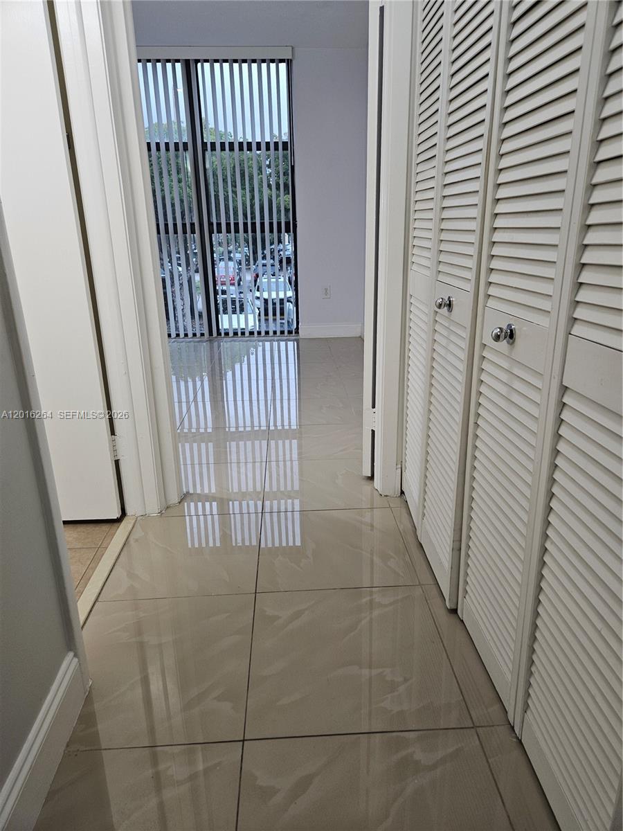 A tiled hallway leads to a room with floor-to-ceiling windows and louvered closet doors — 11780 SW 18th St # 2, Miami FL 33175, MIAMI, FL
