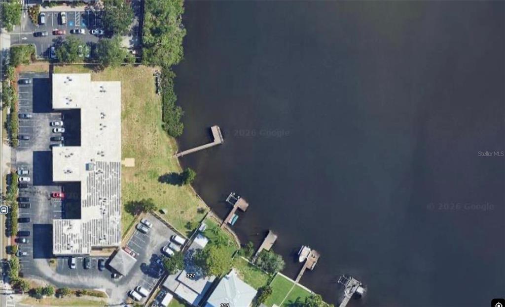 An aerial view shows a building with a parking lot and several docks on water — 8701 4TH STREET N UNIT 105, ST PETERSBURG, FL